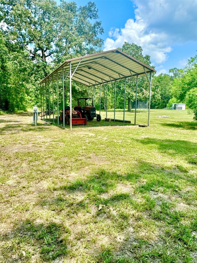 view of parking / parking lot featuring a yard and a carport