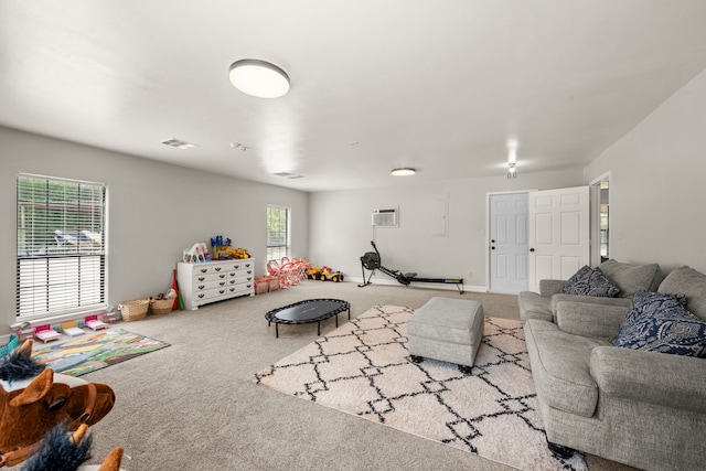 living room with an AC wall unit and carpet floors