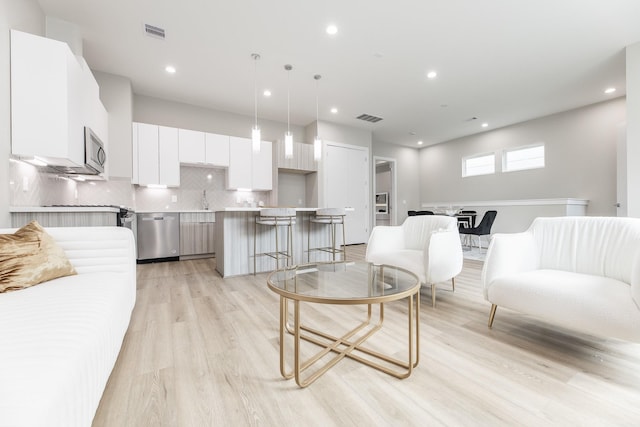 living room featuring sink and light hardwood / wood-style flooring