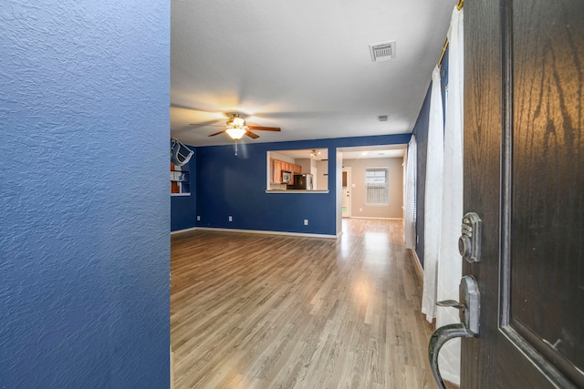 unfurnished living room with ceiling fan and light hardwood / wood-style floors