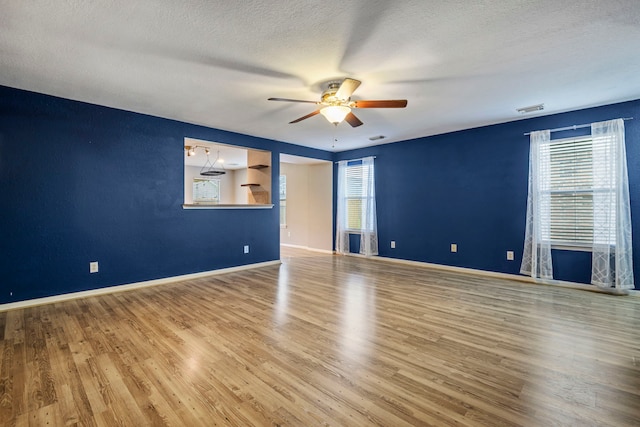 empty room featuring hardwood / wood-style floors, a textured ceiling, and ceiling fan