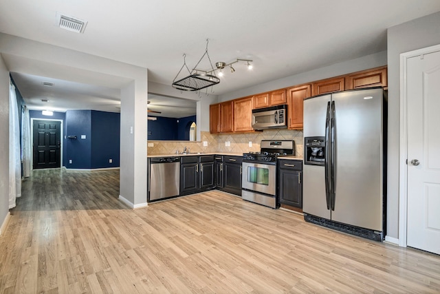 kitchen with backsplash, stainless steel appliances, light hardwood / wood-style floors, and sink