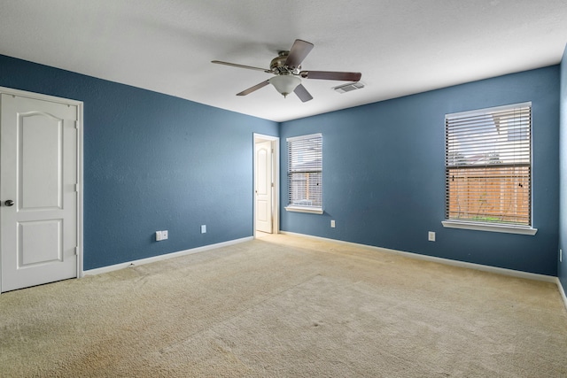 empty room with ceiling fan and light colored carpet