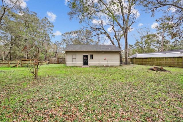 back of house with an outdoor structure and a lawn