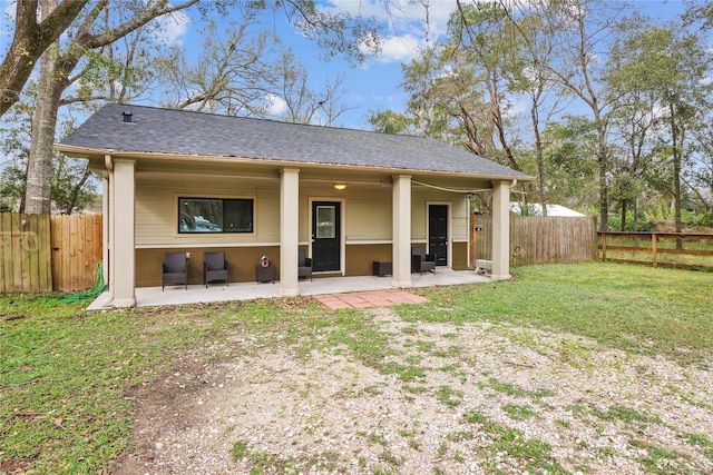 rear view of property featuring a lawn and a patio area