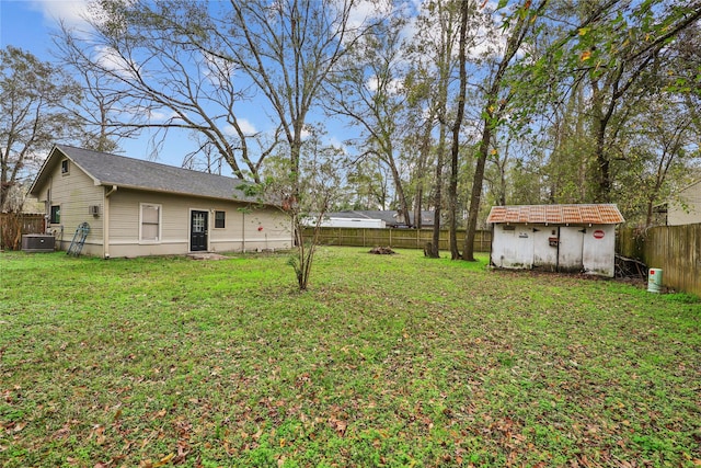 view of yard with central AC unit and a storage shed