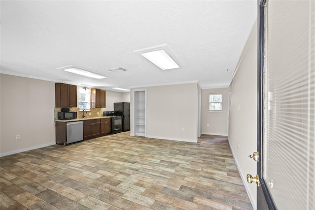 kitchen featuring tasteful backsplash, crown molding, sink, and black appliances