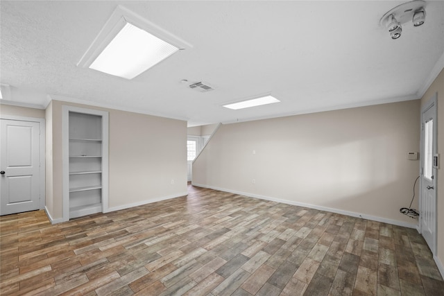 bonus room featuring hardwood / wood-style floors and built in features