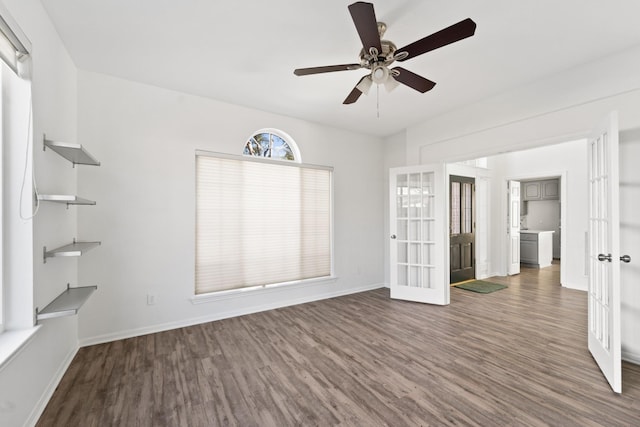 unfurnished room with ceiling fan, dark hardwood / wood-style flooring, and french doors