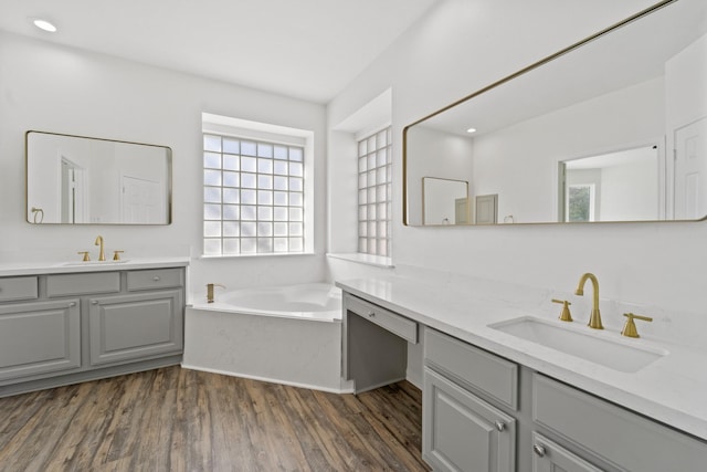 bathroom featuring a bathing tub, vanity, and hardwood / wood-style flooring