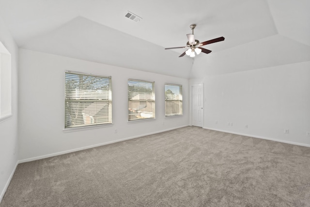 unfurnished room with ceiling fan, lofted ceiling, light carpet, and a tray ceiling