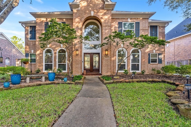 view of front of house featuring a front yard and french doors