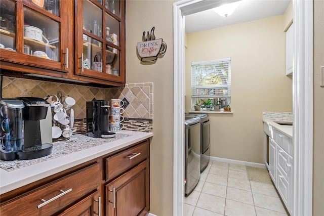 washroom featuring washing machine and clothes dryer and light tile patterned flooring