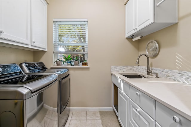 laundry area featuring cabinets, light tile patterned floors, washer and dryer, and sink