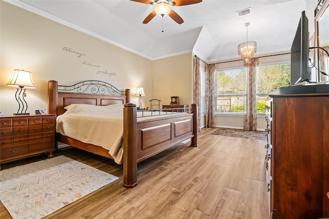 bedroom featuring crown molding, light hardwood / wood-style flooring, and ceiling fan with notable chandelier