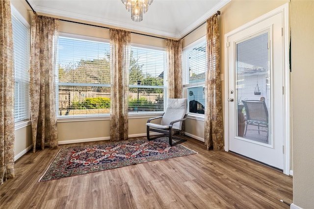 sitting room featuring crown molding, a chandelier, and hardwood / wood-style flooring