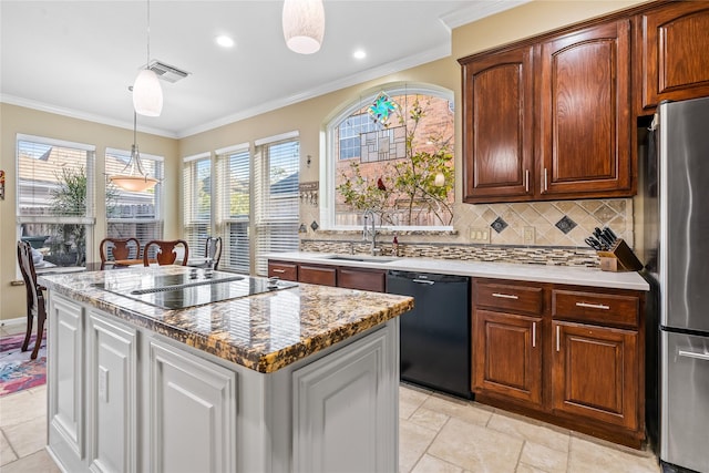 kitchen with black appliances, sink, hanging light fixtures, decorative backsplash, and an island with sink