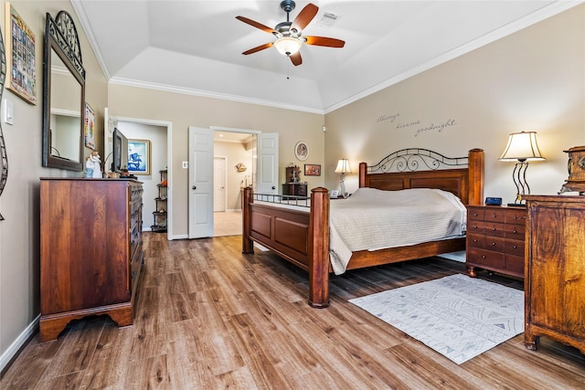 bedroom featuring a tray ceiling, ceiling fan, hardwood / wood-style floors, and ornamental molding