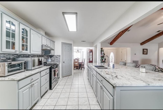 kitchen featuring backsplash, stainless steel appliances, sink, beam ceiling, and light tile patterned floors