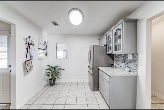 kitchen with gray cabinets, tasteful backsplash, and light tile patterned flooring