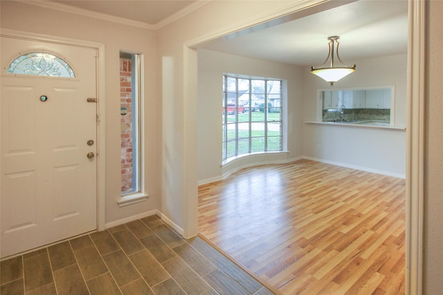 entryway with hardwood / wood-style flooring and ornamental molding