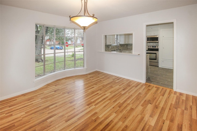 unfurnished dining area with light wood-type flooring and sink