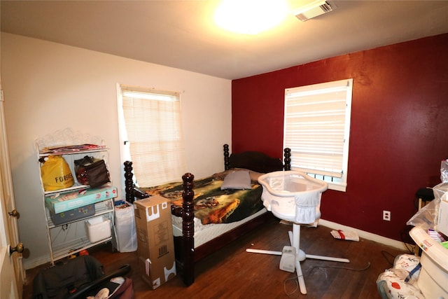 bedroom with dark hardwood / wood-style flooring