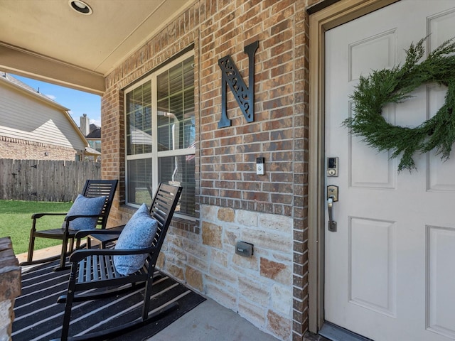 view of exterior entry featuring covered porch