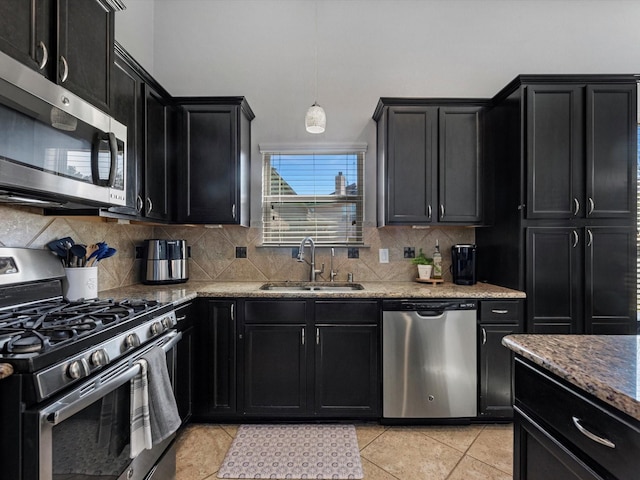 kitchen with sink, light tile patterned floors, tasteful backsplash, decorative light fixtures, and stainless steel appliances