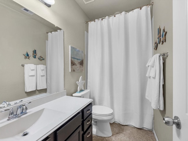 bathroom with tile patterned flooring, vanity, and toilet