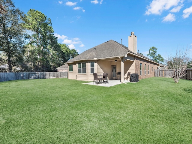 back of house featuring a lawn and a patio