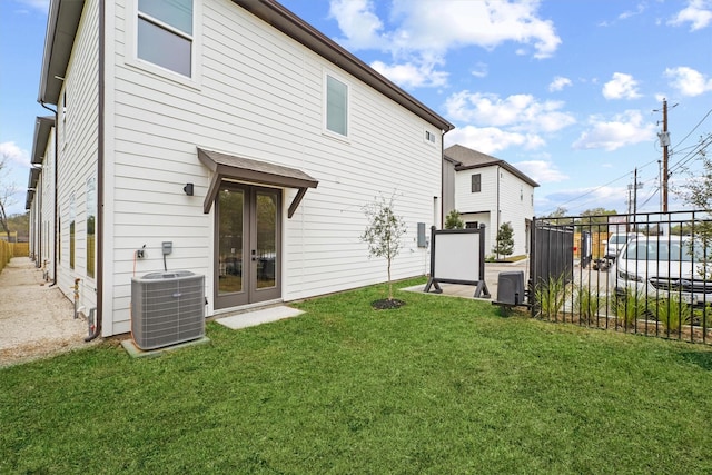 back of house with french doors, a lawn, and central air condition unit