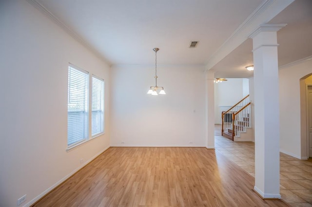 empty room with ornamental molding, light hardwood / wood-style floors, and a notable chandelier