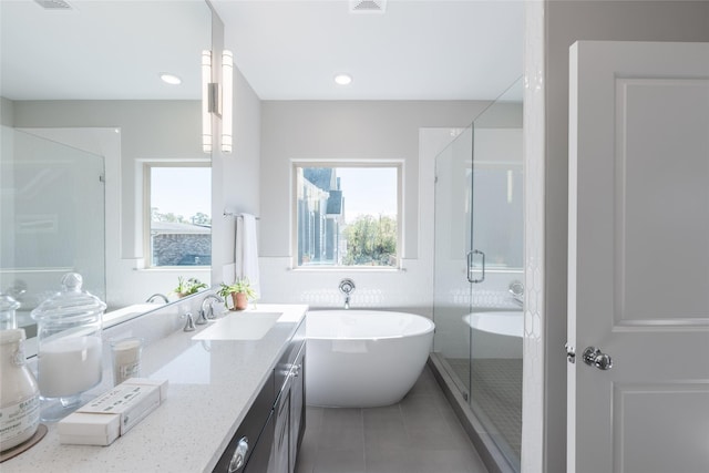 bathroom with tile patterned flooring, vanity, tile walls, and independent shower and bath