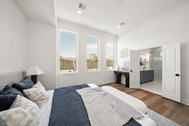 bedroom featuring connected bathroom and hardwood / wood-style floors