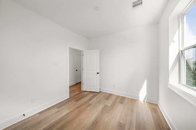 unfurnished room featuring a wealth of natural light and light hardwood / wood-style floors