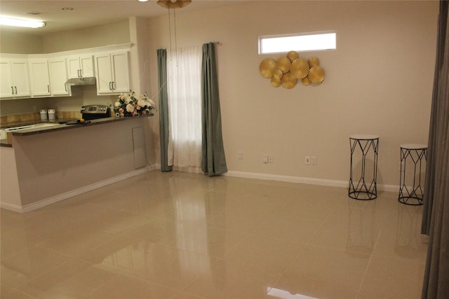 kitchen featuring stainless steel electric stove, white cabinetry, and light tile patterned floors