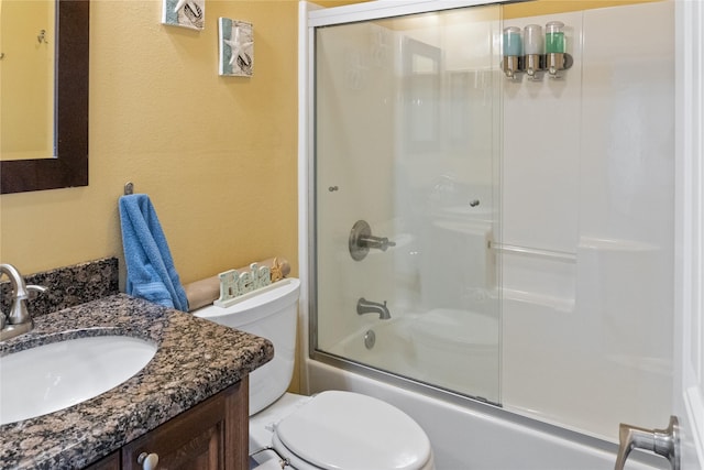 full bathroom featuring vanity, toilet, and bath / shower combo with glass door