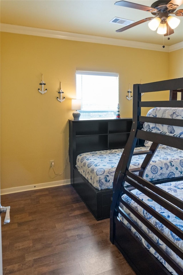 bedroom with dark hardwood / wood-style flooring, ceiling fan, and ornamental molding