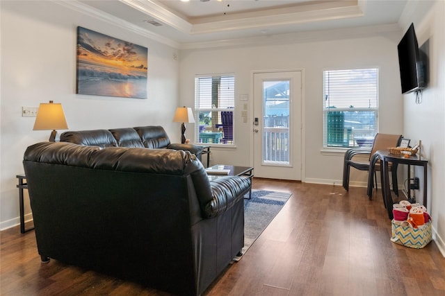 living room with a tray ceiling, dark hardwood / wood-style floors, crown molding, and ceiling fan