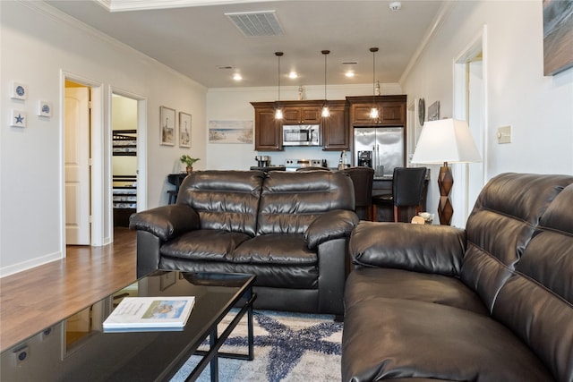 living room with wood-type flooring and ornamental molding