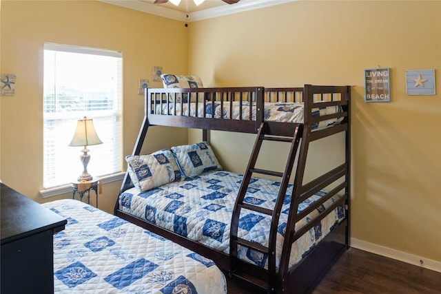 bedroom featuring dark hardwood / wood-style flooring, ceiling fan, and crown molding