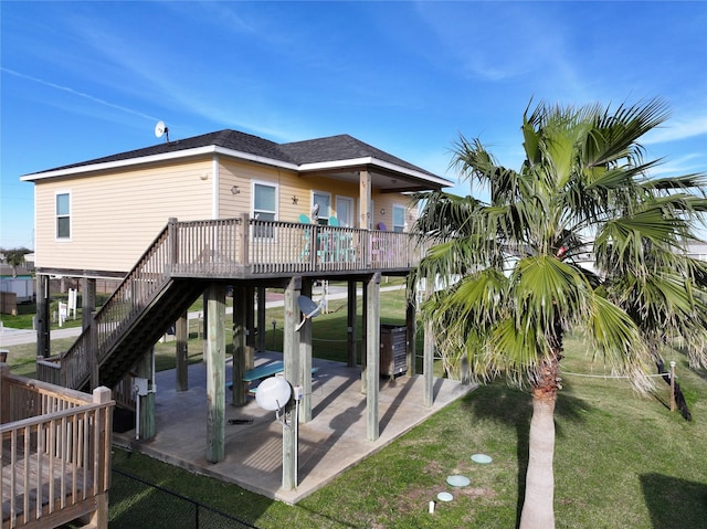 back of property with a lawn, a patio area, and a wooden deck