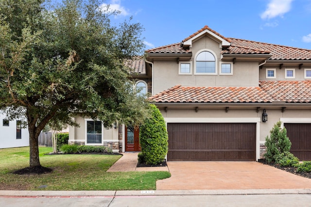 mediterranean / spanish home featuring a front yard and a garage