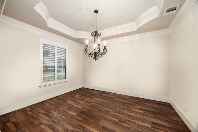 empty room featuring a tray ceiling, an inviting chandelier, dark wood-type flooring, and crown molding