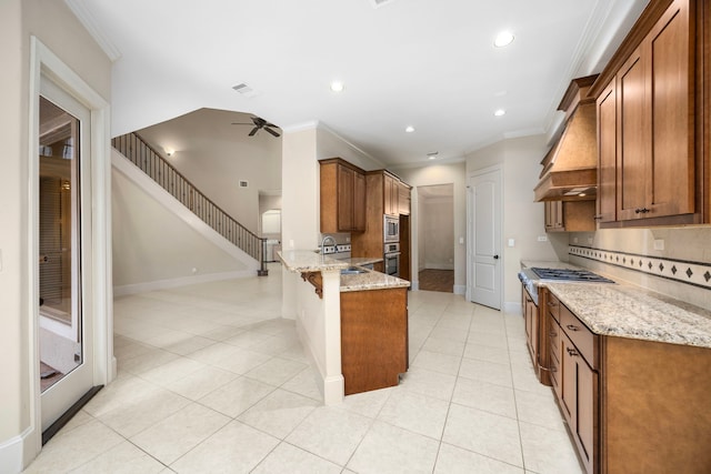 kitchen with sink, light stone counters, premium range hood, kitchen peninsula, and crown molding