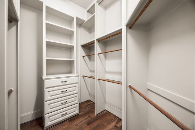 walk in closet with dark wood-type flooring