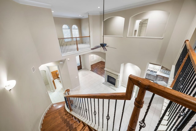 stairway featuring ceiling fan, hardwood / wood-style floors, and ornamental molding