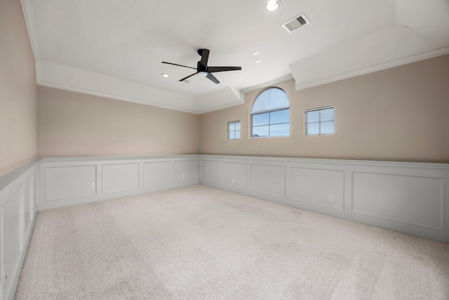 empty room featuring light carpet, ceiling fan, and ornamental molding