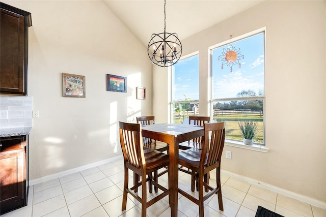 dining space featuring vaulted ceiling, light tile patterned floors, and a notable chandelier